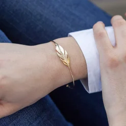 Bracelet plaqué or jaune, motif plume. Diamètre 56 mm.